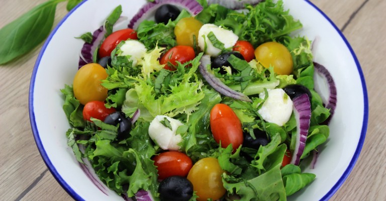 Mediterranean salad with cherry tomatoes black olives mozzarella and basil